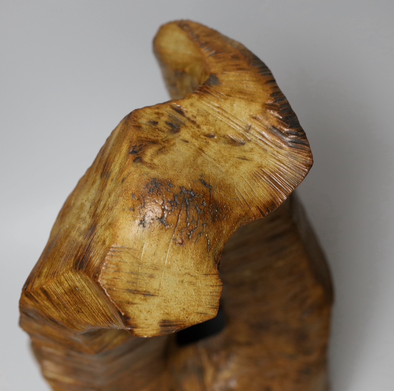 Ruth Sulke - a large brown copper glazed stoneware angular “wooden” sculpture with central hole, 1985, 42cm, See Sulke, Ruth - Ceramic Sculpture by Ruth Sulke, Hanart 2 Gallery, 1987, page 30